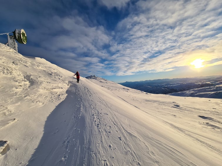 Snow-covered mountain road at sunset